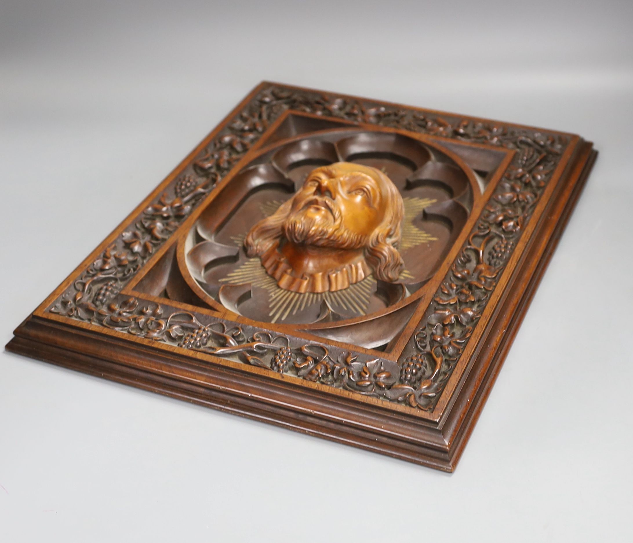 A late 19th century Continental heavily carved walnut and boxwood panel of Christ, a pair of brass lamp bases and two circular stands (5)